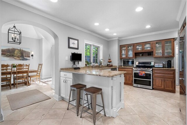 401 Parker Dr, Mt Lebanon, PA 15216 - kitchen with appliances with stainless steel finishes, a peninsula, a kitchen breakfast bar, light tile patterned floors, and ornamental molding