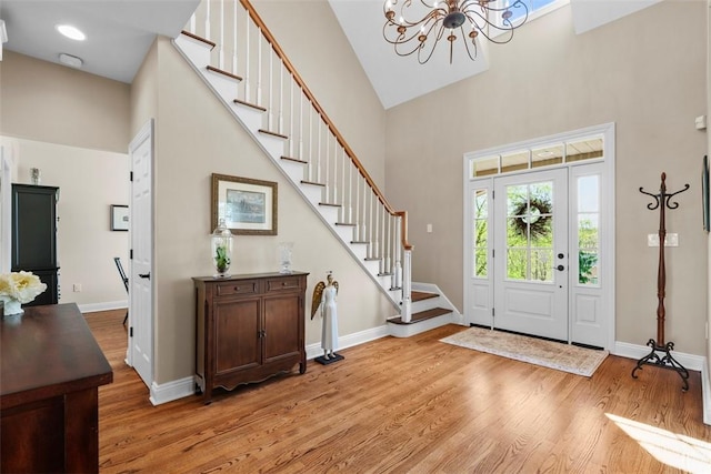 149 Walnut Ridge Dr, Chippewa Twp, PA 15010 - entryway with a towering ceiling, light wood finished floors, stairs, a chandelier, and baseboards