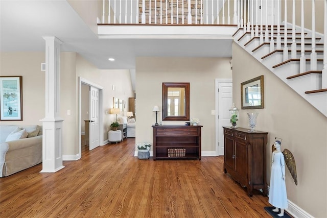 149 Walnut Ridge Dr, Chippewa Twp, PA 15010 - entryway featuring decorative columns, wood finished floors, baseboards, a towering ceiling, and stairs