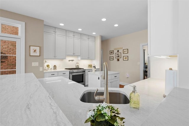 149 Walnut Ridge Dr, Chippewa Twp, PA 15010 - kitchen featuring stainless steel range oven, a sink, light stone countertops, recessed lighting, and white cabinets