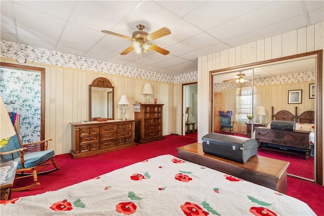 134 Modisette Ave, Donora, PA 15033 - carpeted bedroom featuring wallpapered walls, a paneled ceiling, ceiling fan, a closet, and wood walls