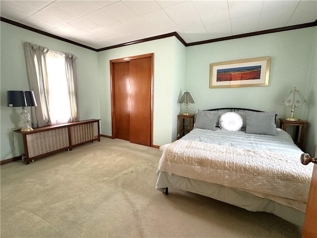bedroom with radiator heating unit, ornamental molding, carpet, baseboards, and a closet
