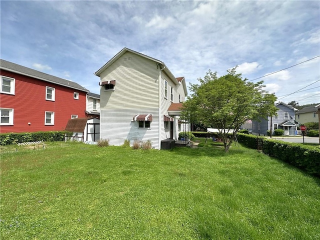 back of house with a lawn, a storage shed, and an outdoor structure