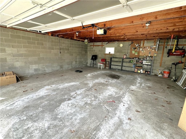 garage with a garage door opener and concrete block wall