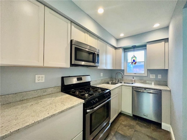 kitchen with stainless steel appliances, a sink, white cabinets, decorative light fixtures, and recessed lighting