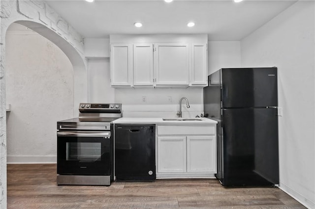 1008 Lowery St, Duquesne, PA 15110 - kitchen featuring black appliances, a sink, white cabinets, arched walkways, and recessed lighting