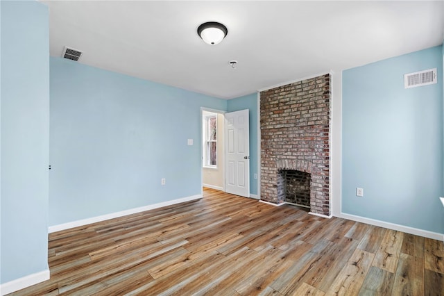unfurnished living room featuring wood finished floors, baseboards, and a fireplace