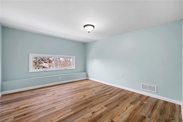 spare room featuring wood finished floors and baseboards