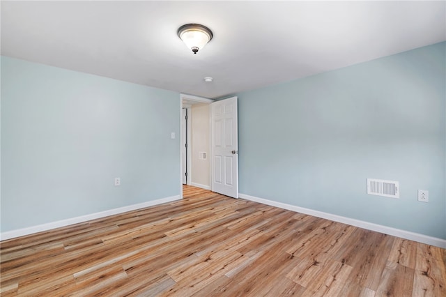 spare room featuring baseboards and light wood-type flooring