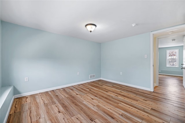 spare room featuring wood finished floors, baseboards, and a smoke detector