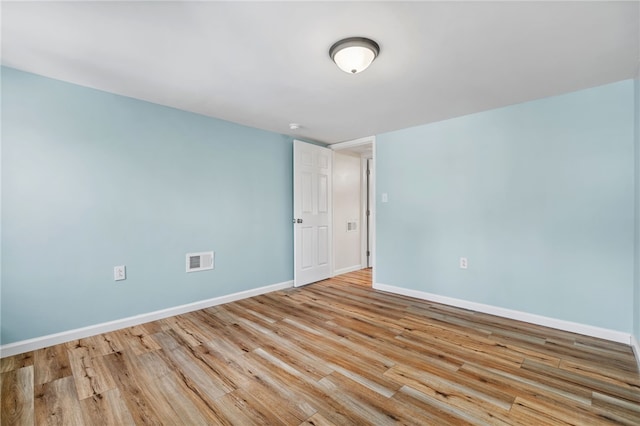 unfurnished room with light wood finished floors and baseboards