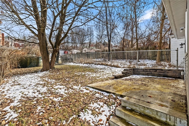 yard layered in snow with a fenced backyard
