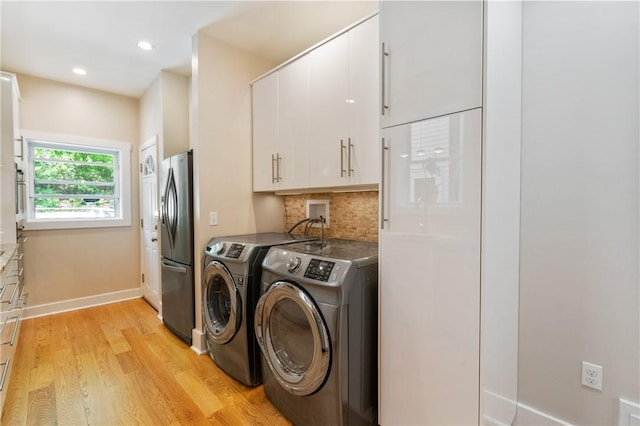 clothes washing area featuring cabinet space, independent washer and dryer, light wood finished floors, baseboards, and recessed lighting