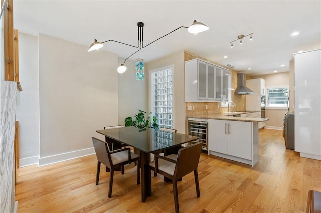 dining area featuring beverage cooler, baseboards, light wood-style flooring, and recessed lighting