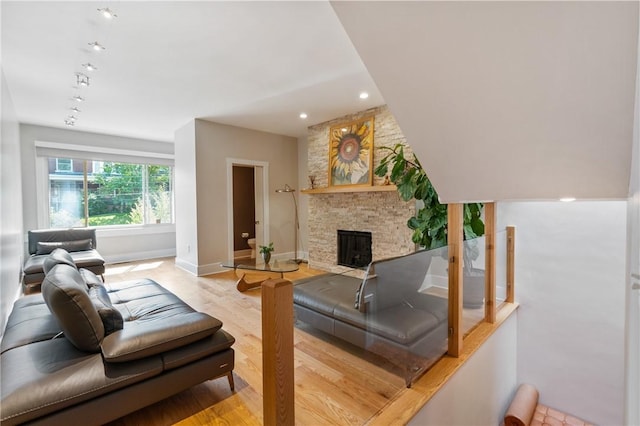 living room featuring baseboards, a fireplace, and light wood-style flooring