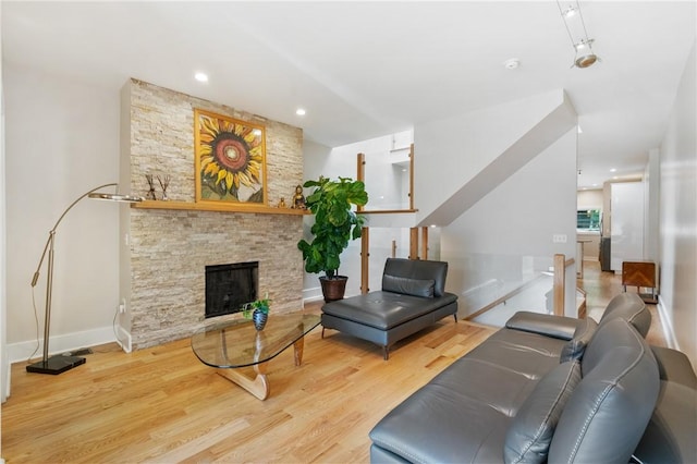 living room with wood finished floors, a fireplace, and baseboards