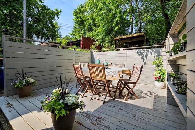 deck with outdoor dining space and fence