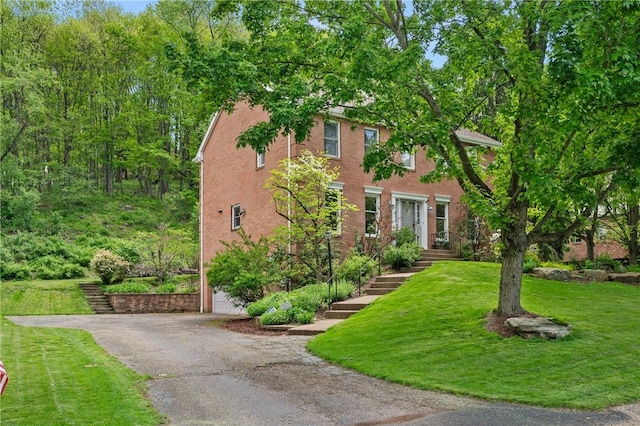 view of front of property featuring a front yard, driveway, and a garage