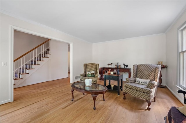 sitting room with wood finished floors, stairs, crown molding, and baseboards