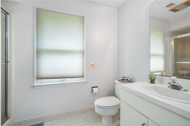 full bathroom with a shower with door, vanity, toilet, and baseboards