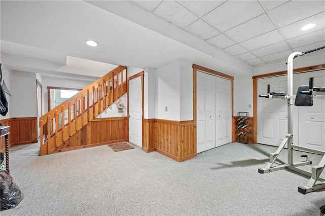 exercise area featuring wainscoting, carpet flooring, recessed lighting, and wooden walls