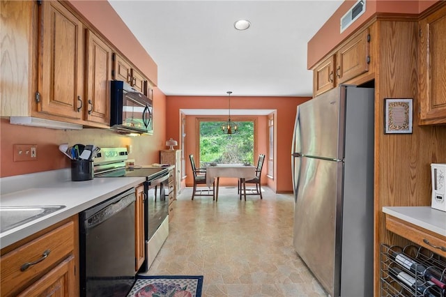 kitchen featuring black appliances, brown cabinets, light countertops, decorative light fixtures, and stone finish flooring