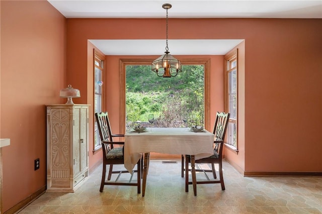 dining area featuring a chandelier, healthy amount of natural light, and baseboards