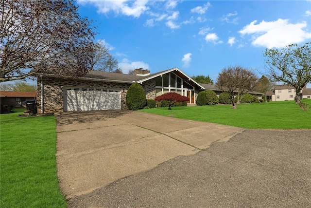mid-century home with a garage, driveway, a front lawn, and a chimney
