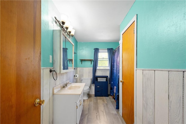 full bathroom with toilet, wainscoting, vanity, wood finished floors, and a shower with shower curtain