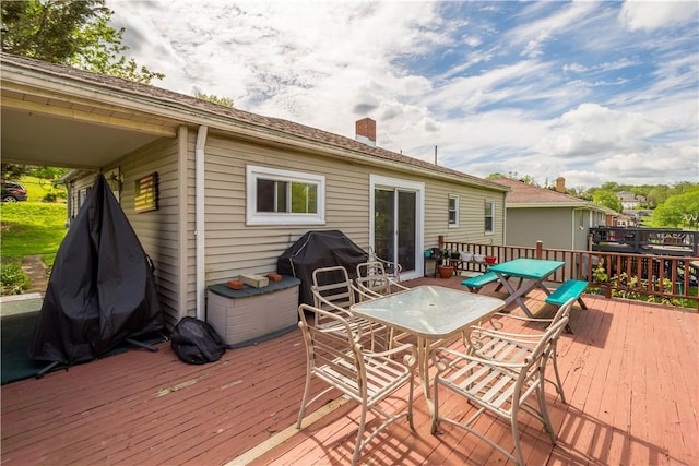 wooden terrace with outdoor dining area and area for grilling