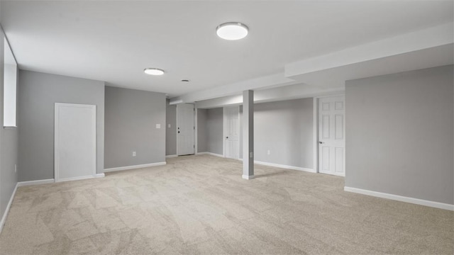 finished basement with light colored carpet and baseboards