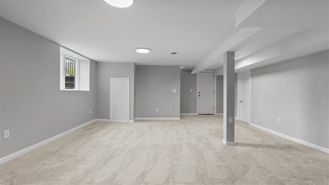 below grade area featuring light carpet and baseboards