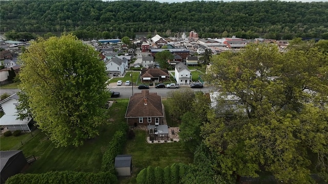 view of property location featuring a forest and nearby suburban area