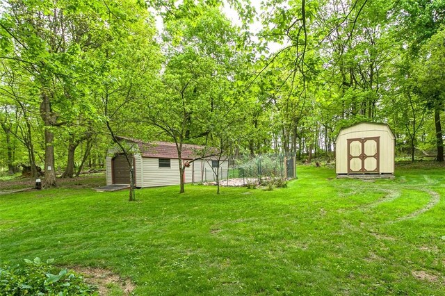 view of green lawn with a shed and an outbuilding
