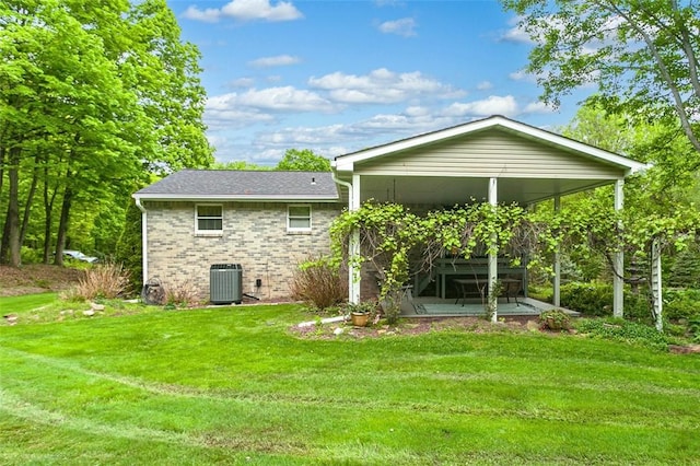 back of house with a lawn, a patio, cooling unit, and brick siding