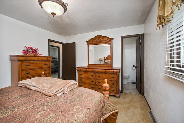 bedroom with light carpet and connected bathroom