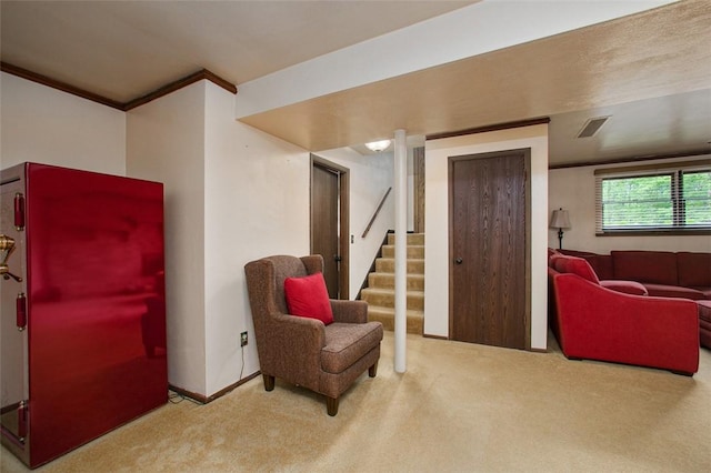living area with carpet flooring, ornamental molding, and stairway