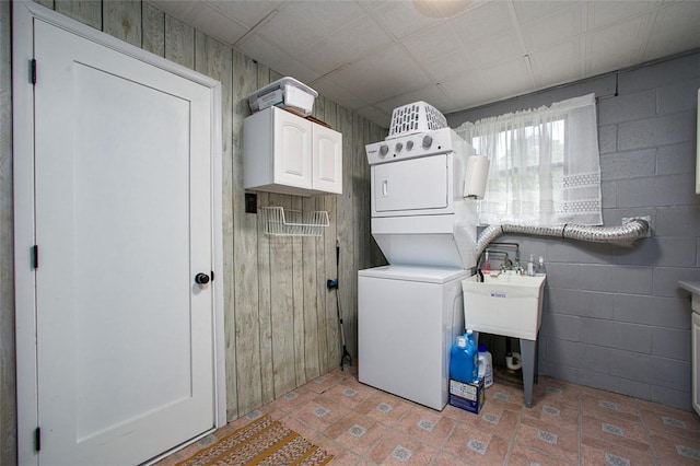 laundry room featuring cabinet space and stacked washer / drying machine