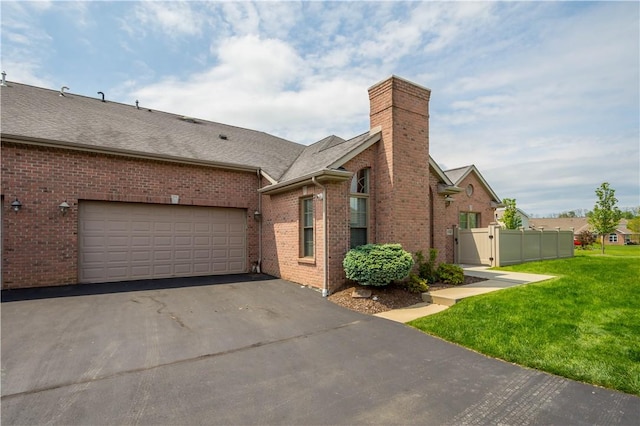 112 Shelton Place Dr, Connoquenessing Boro, PA 16033 - view of front facade featuring asphalt driveway, a chimney, brick siding, a gate, and a garage