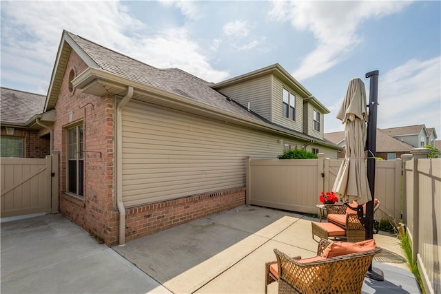 112 Shelton Place Dr, Connoquenessing Boro, PA 16033 - view of side of property featuring a gate, a patio, a shingled roof, brick siding, and fence