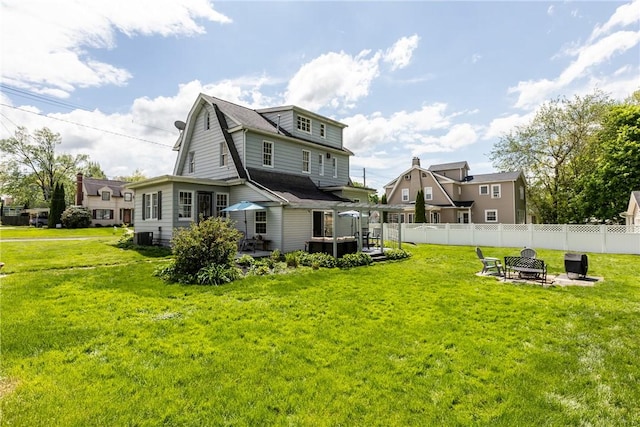 rear view of house with a fire pit, a wooden deck, and central AC