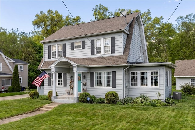 view of front of home featuring roof with shingles, central AC, and a front lawn