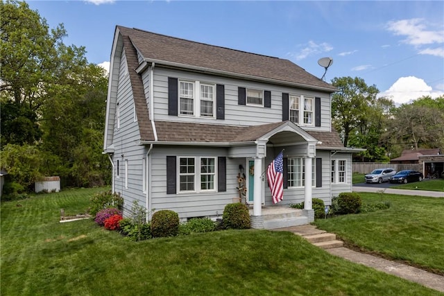 view of front of home featuring a shingled roof and a front yard
