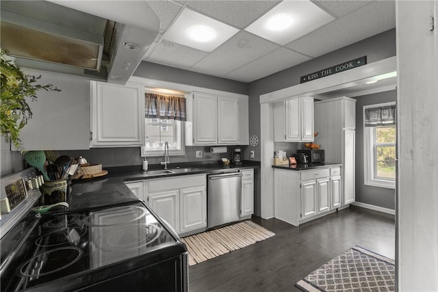 kitchen with a sink, dishwasher, black / electric stove, dark countertops, and white cabinetry