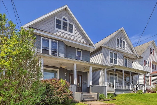 view of front of house with covered porch, ceiling fan, and a front lawn