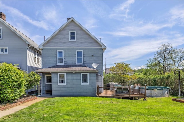 rear view of house featuring a wooden deck and a yard