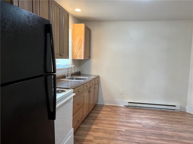 kitchen featuring freestanding refrigerator, a sink, white range with electric stovetop, light wood-style floors, and a baseboard heating unit