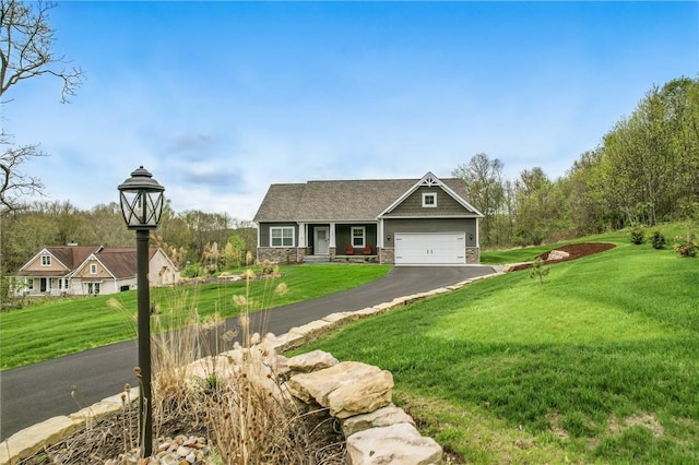 craftsman-style house with stone siding, a front lawn, driveway, and an attached garage