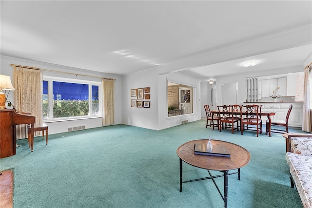 carpeted living room with ornamental molding
