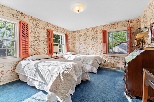 carpeted bedroom featuring wallpapered walls and baseboards